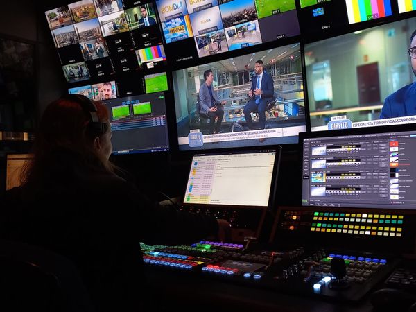  A woman in front of numerous monitors and control panels