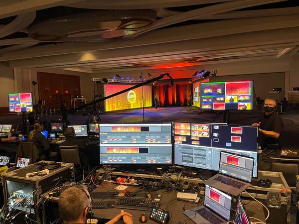 A man in studio is checking  video on a few screens